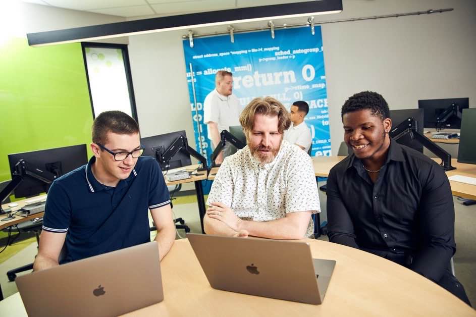 David et 2 étudiants dans un local d'informatique